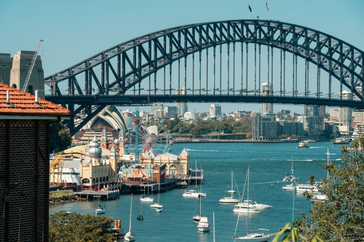 Sydney Harbour Bridge with Luna Park and sailboats on the harbour.