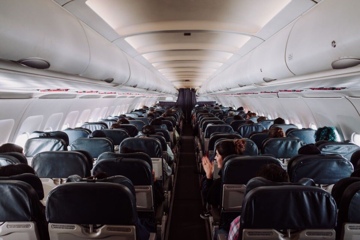 a view of passengers seated inside a commercial airplane cabin during flight | Two Scots Abroad A view of passengers seated inside a commercial airplane cabin during flight.