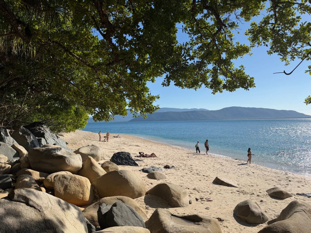 beautiful sandy beach with people lush greenery and clear blue sea at tropical n | Two Scots Abroad Beautiful sandy beach with people, lush greenery, and clear blue sea at Tropical North Queensland.
