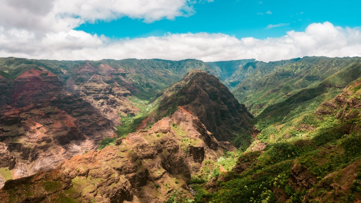Breathtaking aerial view of Waimea Canyon's vibrant cliffs and lush greenery in Hawaii.