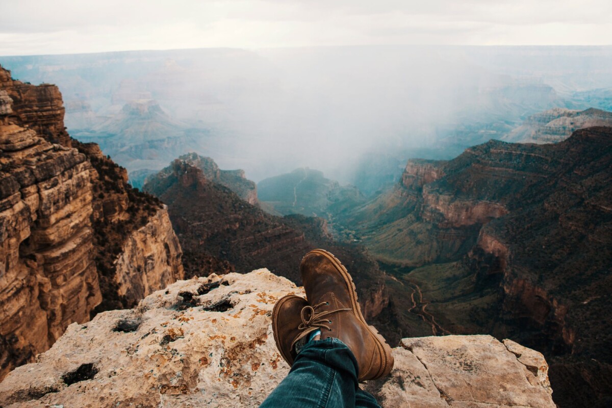 brown boots on a rocky perch overlooking the vast grand canyon landscape | Two Scots Abroad Brown boots on a rocky perch overlooking the vast Grand Canyon landscape.