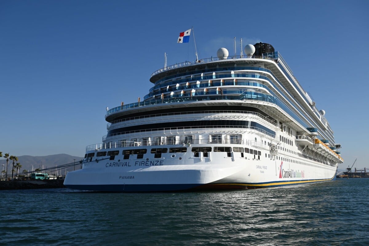 Carnival Firenze cruise ship docked in port under a clear blue sky.