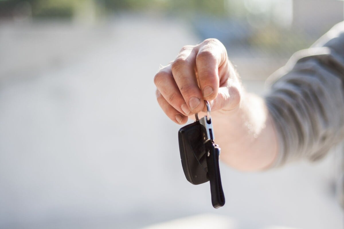 close up of a hand handing over car keys signifying purchase or rental | Two Scots Abroad Close-up of a hand handing over car keys, signifying purchase or rental.