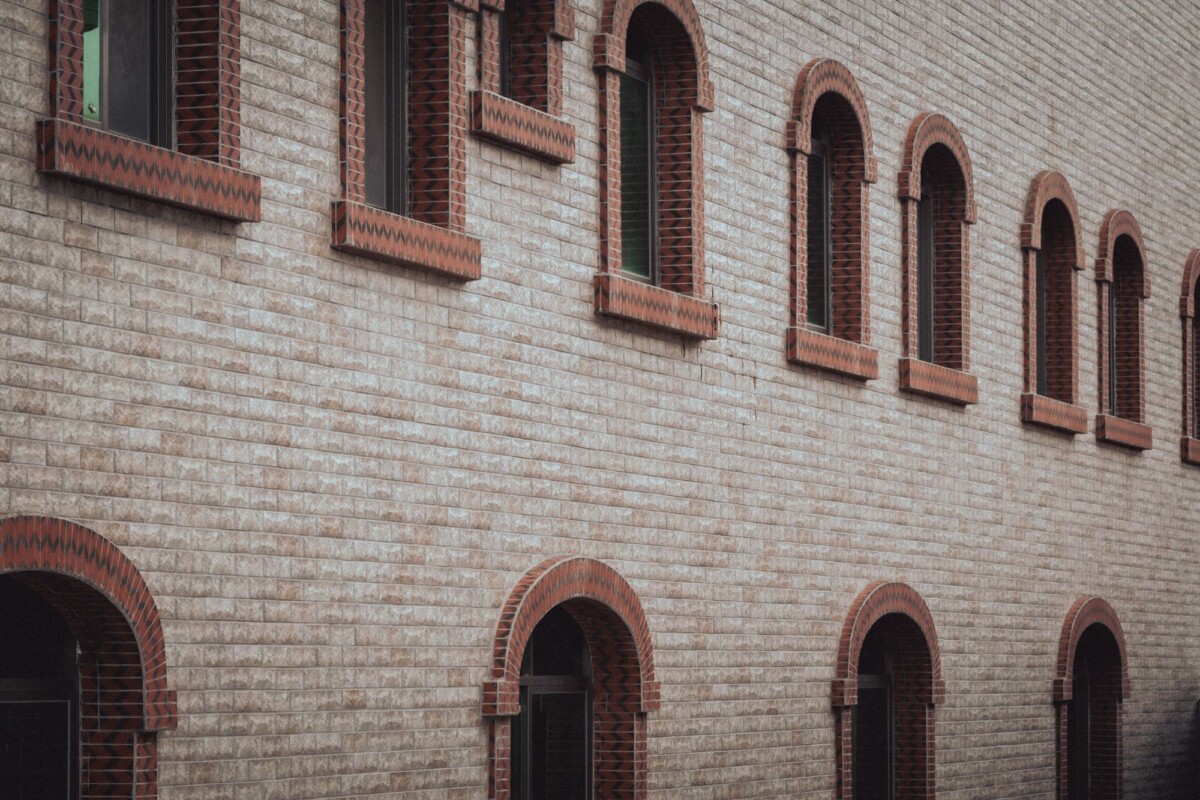 exterior view of a brick building featuring symmetrical arched windows in a clas | Two Scots Abroad Exterior view of a brick building featuring symmetrical arched windows in a classic style.