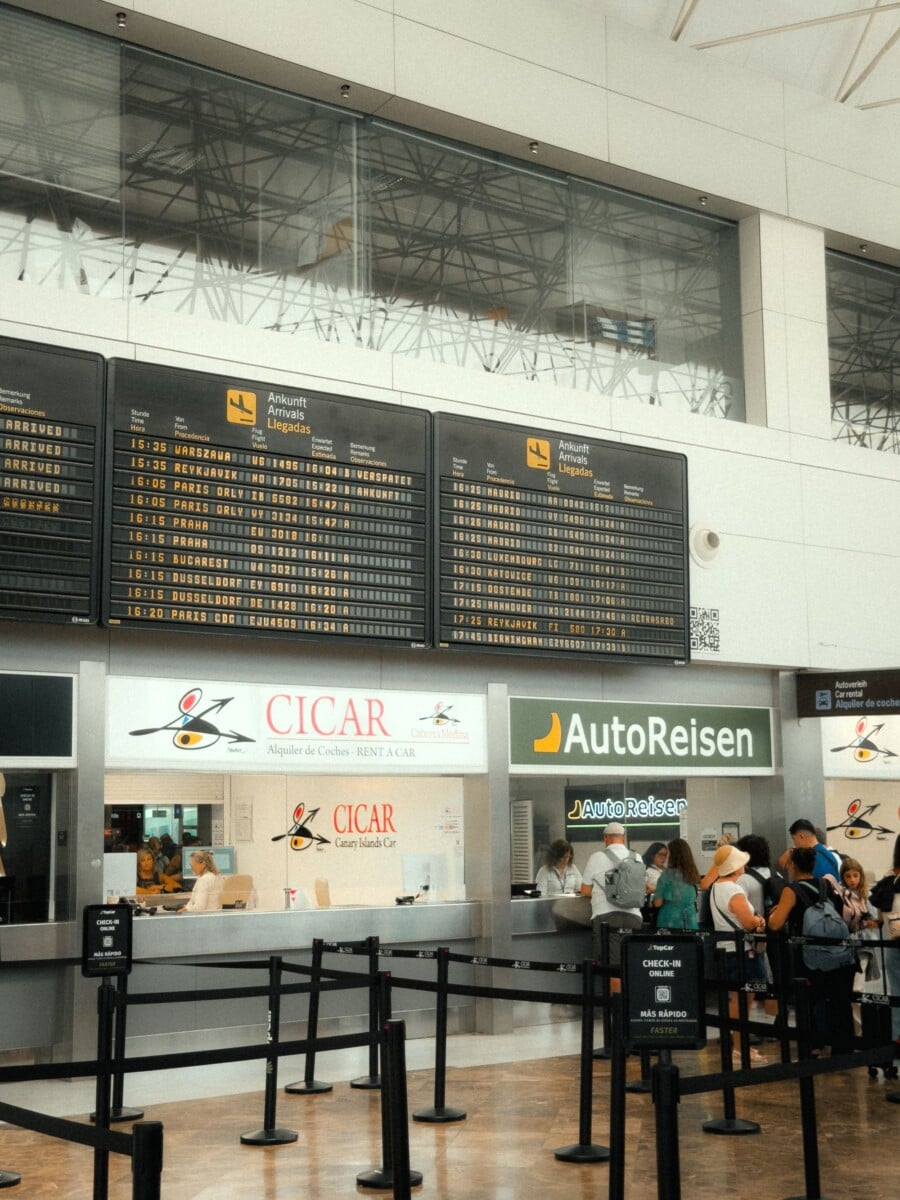 passengers waiting at cicar and autoreisen counters in a busy airport in the can | Two Scots Abroad Passengers waiting at Cicar and AutoReisen counters in a busy airport in the Canary Islands.