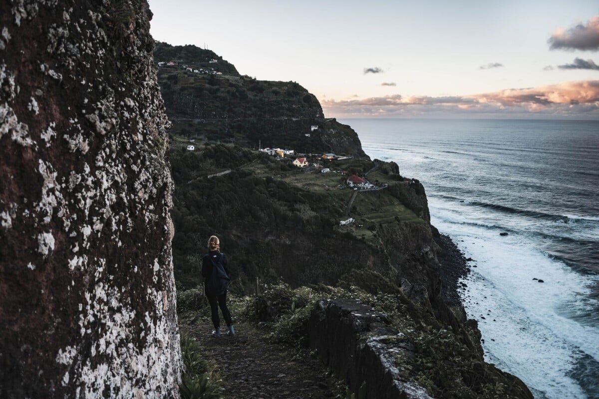 person walking on a cliffside trail in madeira portugal during the evening | Two Scots Abroad Person walking on a cliffside trail in Madeira, Portugal during the evening.