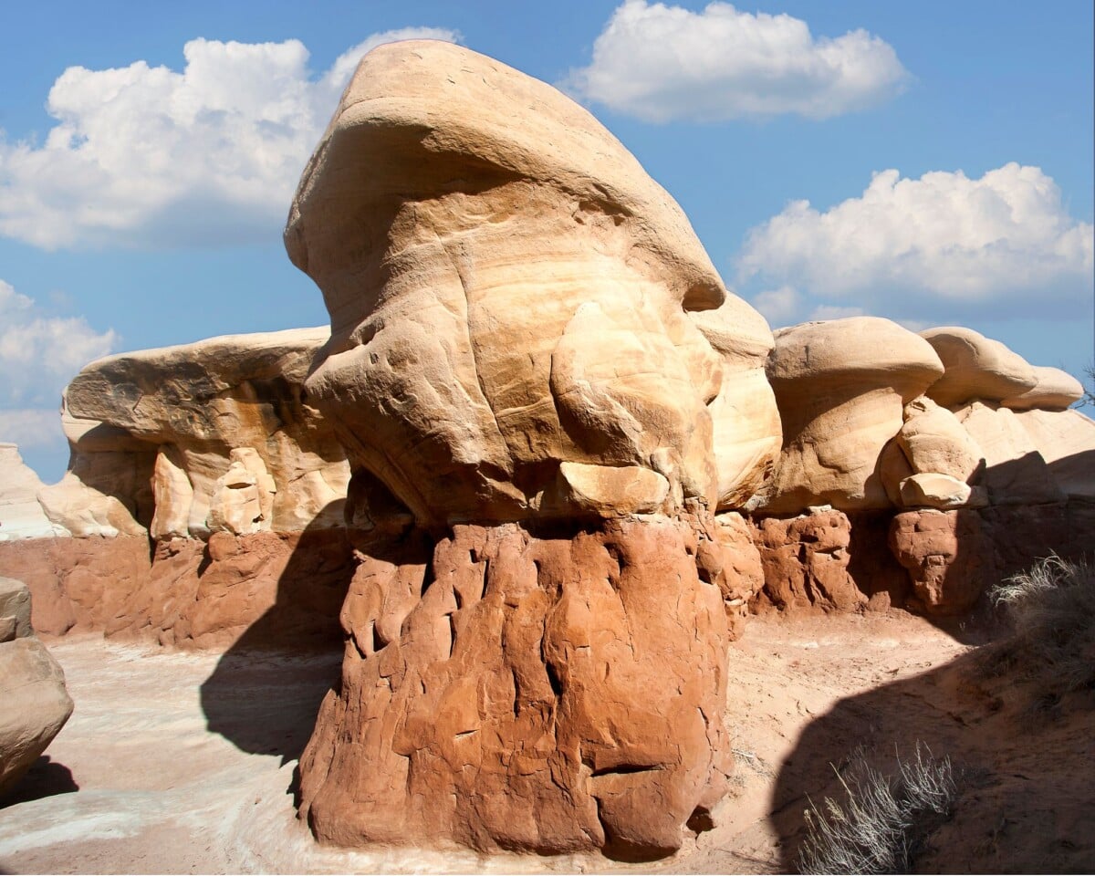 stunning sandstone rock formations in an arid desert landscape under a clear blu | Two Scots Abroad Rounded sandstone caps balanced above weathered hoodoo pillars