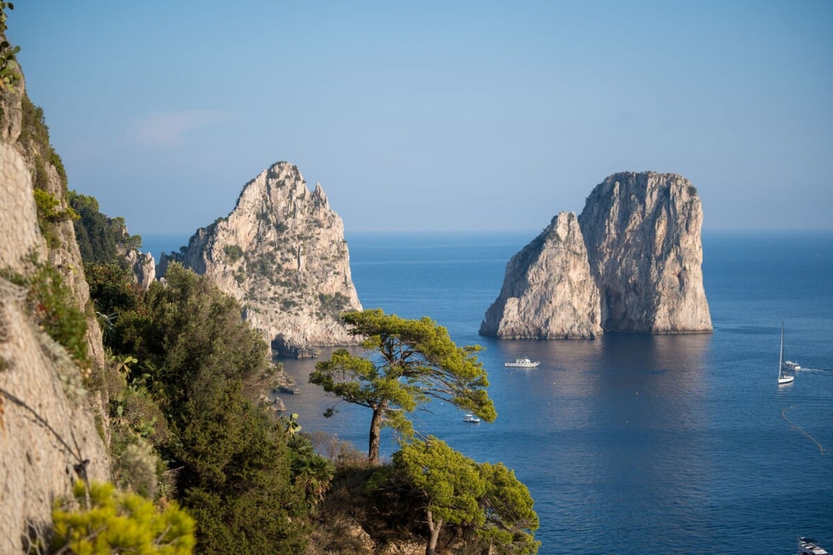 Stunning scenic view of the Faraglioni rock formations and sea in Capri, Italy, under clear blue skies.