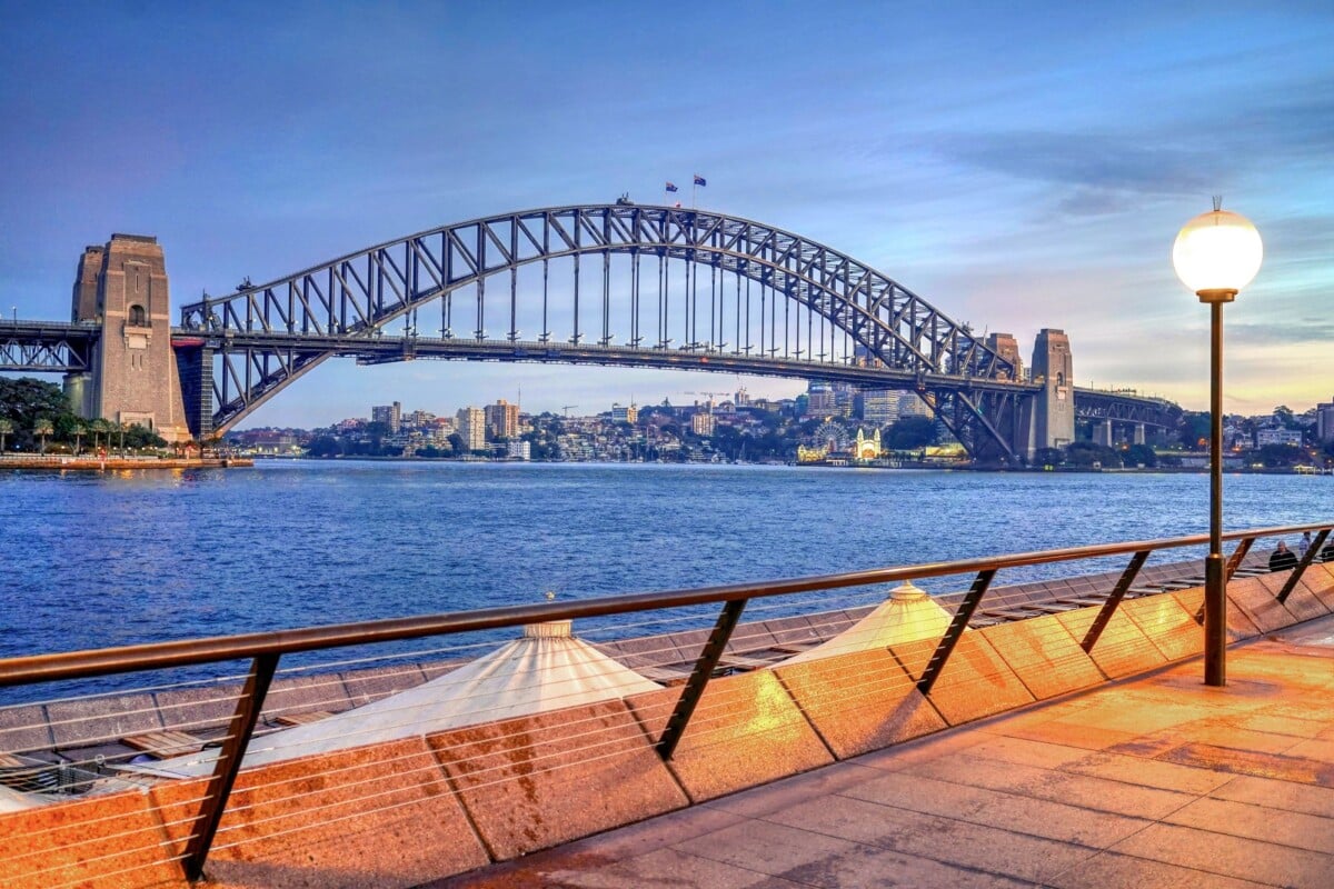 Sydney Harbour Bridge over the harbour at twilight.