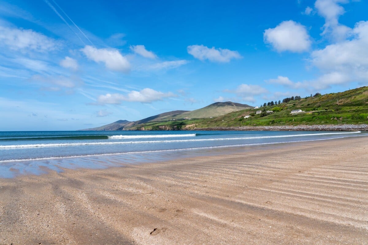 tranquil beach with rolling waves and lush hills on dingle peninsula ireland | Two Scots Abroad Tranquil beach with rolling waves and lush hills on Dingle Peninsula, Ireland.