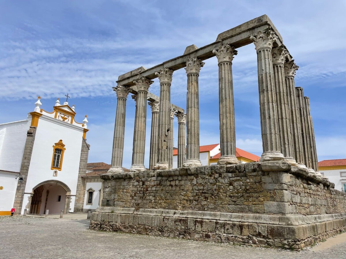 view of the roman temple and a baroque church facade in evora under a blue sky | Two Scots Abroad View of the Roman Temple and a Baroque church facade in Évora under a blue sky.